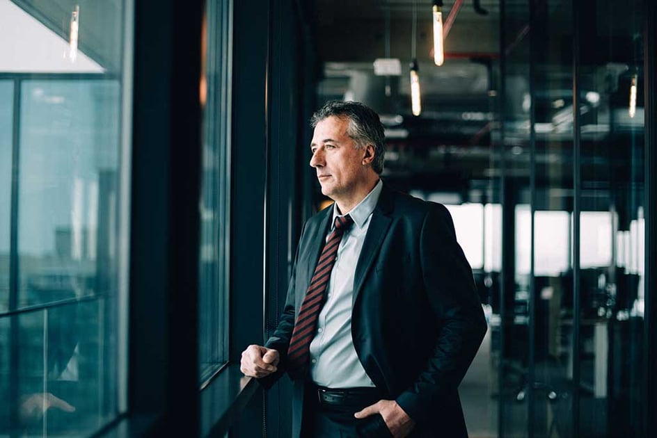 Business man looking out window | How tog et a franchise loan